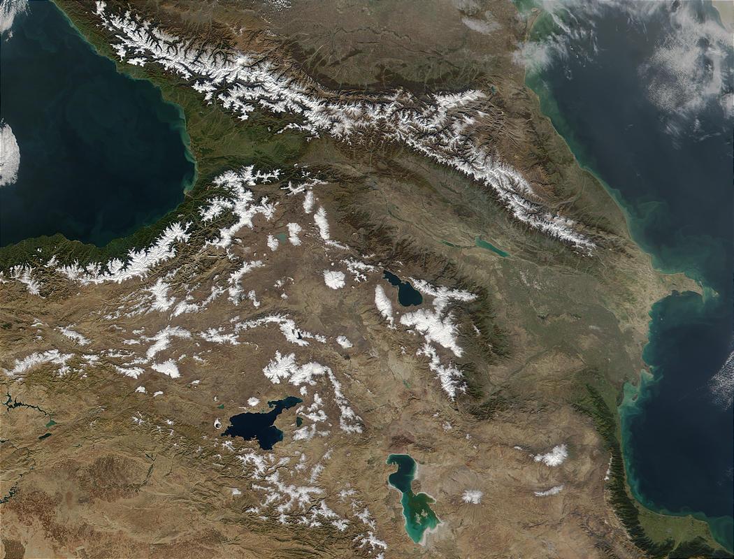 Often regarded as the southeastern border of Europe, the Caucasus Mts stretch from the Black Sea (left) to the Caspian Sea (right). The mountain range spans 1,125 km (700 mi), forming part of the southern Russian border, and crossing Georgia, Armenia, and Azerbaijan from left to right respectively. With a snowline of approximately 3,350 m (11,000 ft) and many peaks over 4,500 m (14,760 ft), much of the snow seen in this image is present year round. Also visible in this photo are apparent phytoplankton blooms in the Caspian Sea, marked by blue-green swirls. Image credit: NASA.