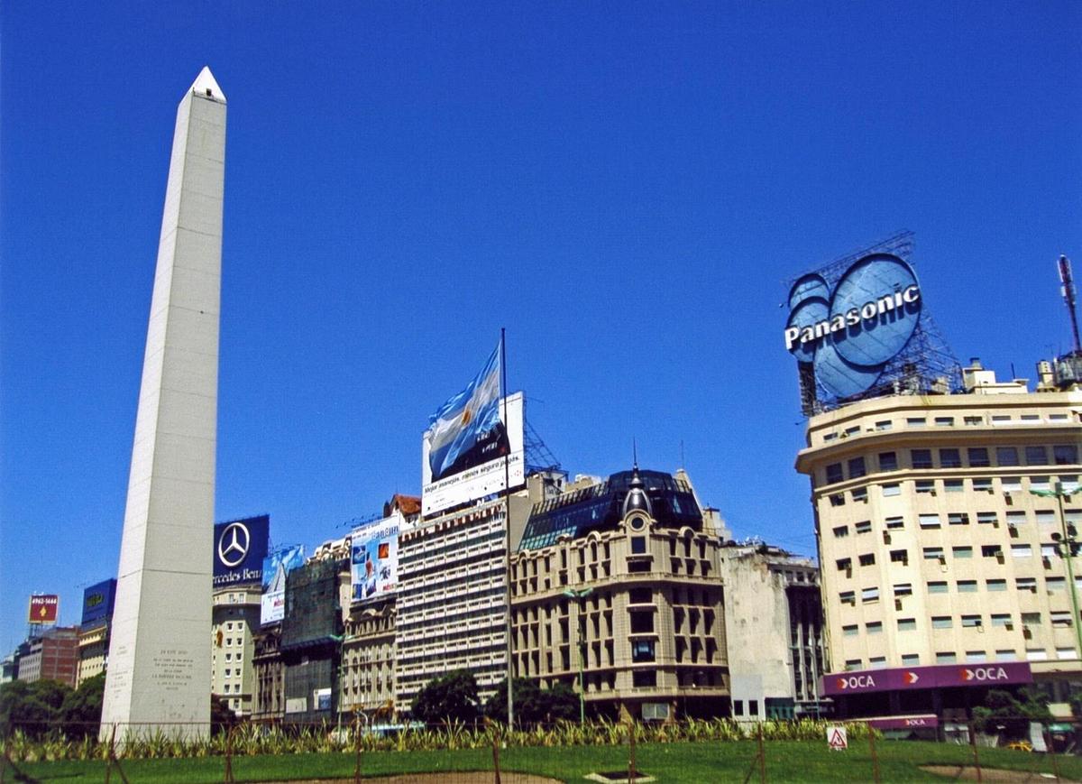 The Obelisk (El Obelisco) along Nueve de Julio Avenue in Buenos Aires. The thoroughfare, named after Argentina's independence day (9 July 1816), is generally considered the widest avenue in the world. The Obelisk, built in 1936, measures 67 meters high (220 feet) and commemorates the founding of the city.