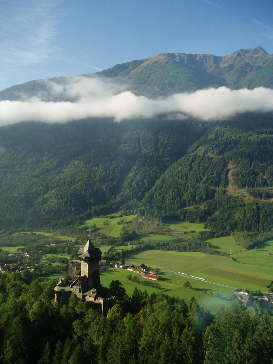 A castle and mountain valley in the Alps.