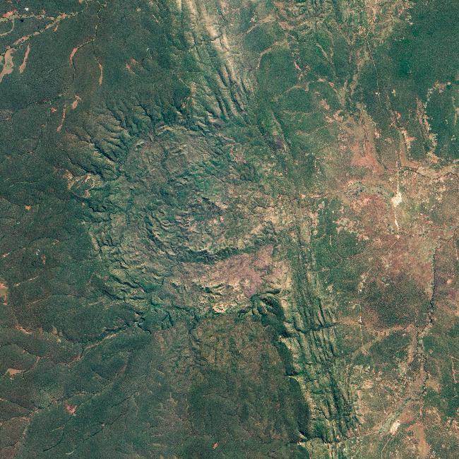 This astronaut image shows two capital cities (brownish-gray areas) on opposite banks of the Congo River. The smaller city on the north side of the river is Brazzaville, while the larger, Kinshasa, is on the south side. The cities lie at the downstream end of an almost circular widening in the river known as Stanley Pool. The international boundary follows the south shore of the pool (roughly 30 km in diameter). The Republic of the Congo, originally a French colony, is sometimes called Congo-Brazzaville - as opposed to the Democratic Republic of the Congo (known from 1971 to 1999 as Zaire) which is often called Congo-Kinshasa, originally a Belgian colony. Brazzaville's population is less than a tenth of Kinshasa's. There is no bridge between the cities so that water craft of many kinds ply between them. It is not uncommon to see dugout canoes being paddled between the cities. Photo courtesy of NASA.