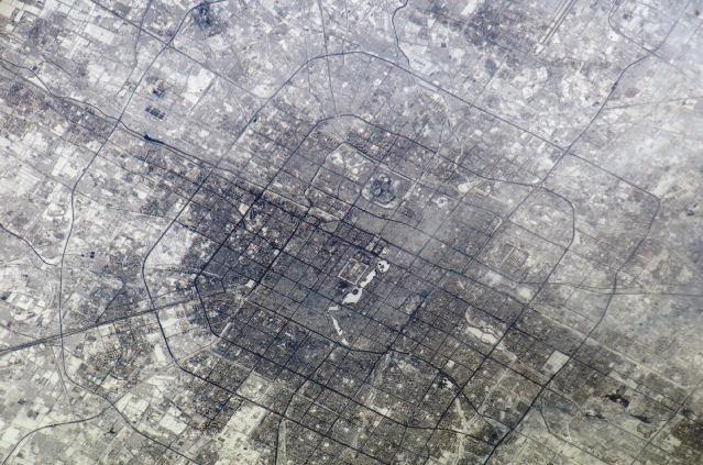 The concentric street patterns of Beijing are clearly visible in this photo taken from the International Space Station. The rectangular area in the center is the Palace Museum also known as the Forbidden City. The area of buildings north of the Forbidden City contains a number of universities. Beijing is surrounded by six ring roads or beltways, four of which may be seen in this photo. The 1st Ring Road no longer functions as an expressway. Image courtesy of NASA.