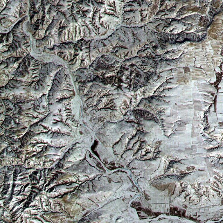 An area in northern Shanxi Province imaged on 9 January 2001. The low sun angle and light snow cover highlight a section of the Great Wall, visible as a black line snaking diagonally through the image from lower left to upper right. The Great Wall (actually a series of walls) is over 2,000 years old and was built over a period of 1,000 years. Stretching 8,850 km (5,500 mi) from Korea to the Gobi Desert, it was built to protect China from northern marauders. Click on photo for higher resolution. Image courtesy of NASA.