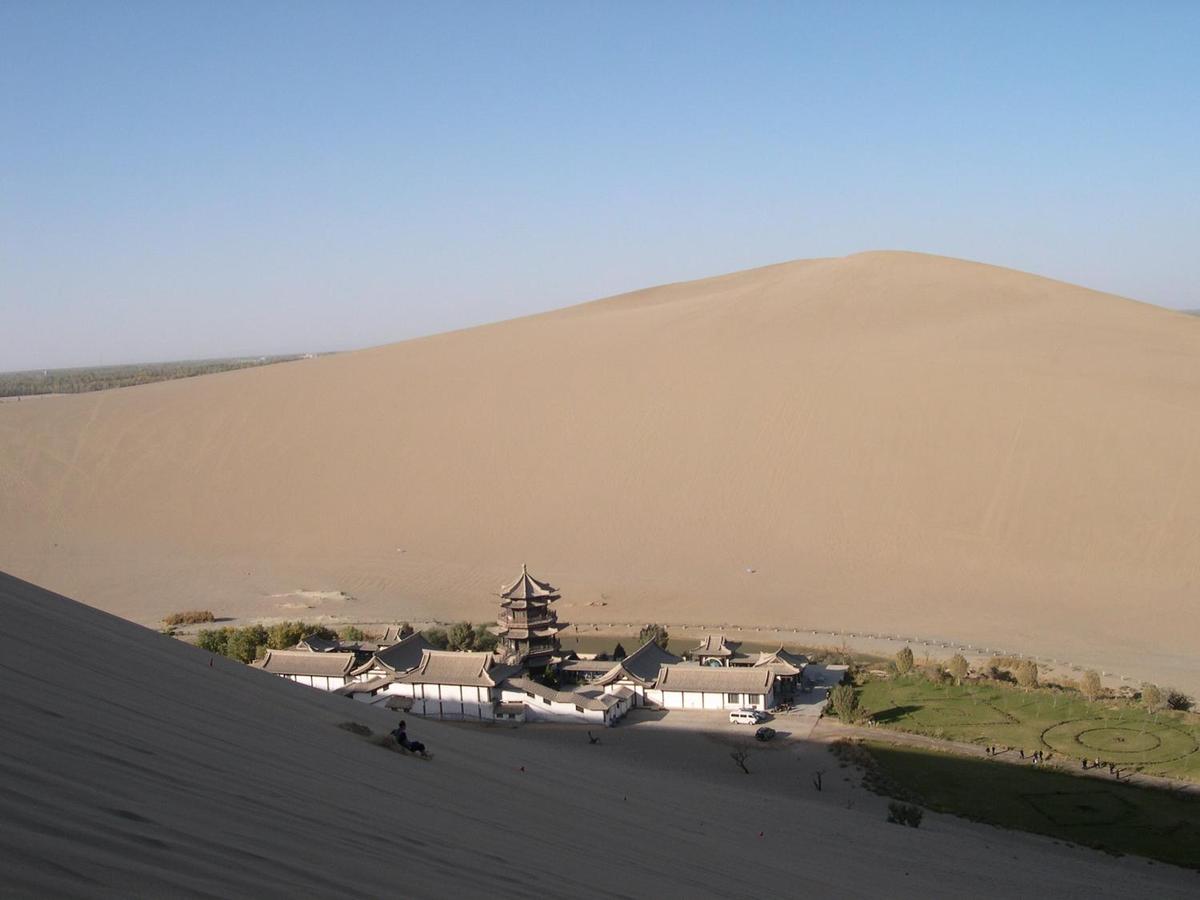 Crescent Moon Lake is an oasis in the Singing Sands Mountains, six kilometers south of Dunhuang. The lake gets its name from its shape. Activities in this area include camel riding, dune paragliding, and sand sledding. Most tourists visit in the evening to avoid the heat.