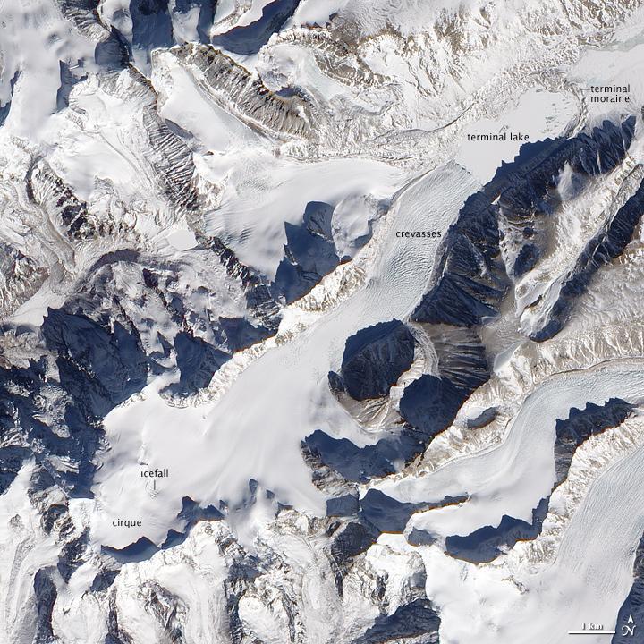 Besides the world's tallest peaks, the Himalayan Mountain Range holds thousands of glaciers. In southern China, just north of the border with Nepal, one unnamed Himalayan glacier flows from southwest to northeast, creeping down a valley terminating in a glacial lake. Shown in this natural-color satellite image, mountains on either side of the glacier cast long shadows to the northwest. From a bowl-shaped cirque, the glacier flows downhill. Where the ice passes over especially steep terrain, ripple marks on the glacier surface indicate the icefall. Northeast of the icefall, the glacier's surface is mostly smooth for several kilometers until a network of crevasses mark the surface. At the end of the glacier's deeply crevassed snout sits a glacial lake, coated with ice in this wintertime picture. Just as nearby mountains cast shadows, the crevassed glacier casts small shadows onto the lake's icy surface. This glacial lake is bound by the glacier snout on one end, and a moraine - a mound formed by the accumulation of sediments and rocks moved by the glacier - on the other. Image courtesy of NASA.