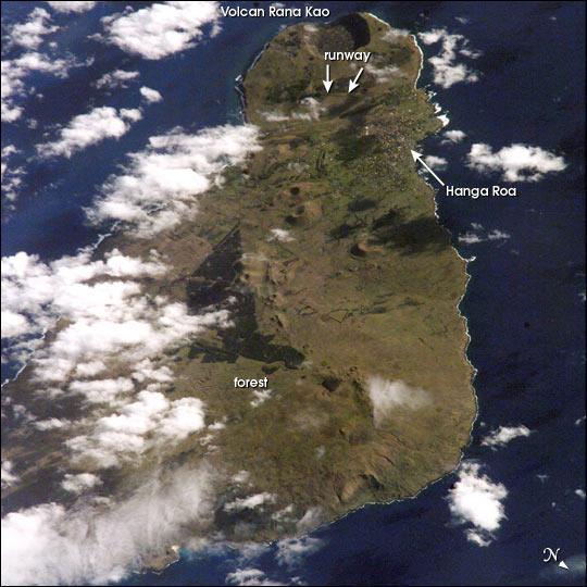 View of Easter Island from space. The island is one of the most remote locations on Earth, being more than 3,200 km (2,000 mi) from the closest populations on Tahiti or Chile. The island is perhaps most famous for the giant stone monoliths, known as moai, that have been placed along the coastline. Archaeologists believe the island was discovered and colonized by Polynesians sometime between A.D. 400 and 700. Subsequently, a unique culture developed. The human population grew to levels that could not be sustained by the island. A civil war resulted, and the island's deforestation and ecosystem collapse was nearly complete. Today, a new forest (primarily eucalyptus) has been established in the center of the island (dark green). Less than 25 km (15 mi) long, the geography of the island is dominated by volcanic landforms, including the large crater Rana Kao at the southwest end of the island and a line of cinder cones that stretch north from the central mountain. A final feature (difficult to see) is the very long runway (Chile's longest) near Rana Kao, which served (but was never used) as an emergency landing site for the Space Shuttle. Image courtesy of NASA.