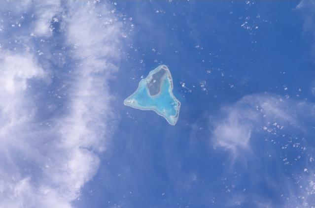 Aitutaki in the Southern Cook Islands has a distinctive equilateral triangular shape (roughly 12 km (7.5 mi) on each side). It is an "almost atoll" whose coral reef barrier does not extend above the ocean along its southern side. Image courtesy of NASA.
