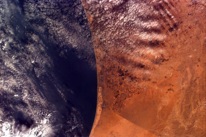 This image covers an area roughly 100x150 km; due to shuttle orientation, north is located at approximately eleven o'clock in this image. Shown are the Gaza Strip (roughly the center third of the coastal strip) and the Mediterranean Sea. The straight-line Egypt-Israel border is apparent in the lower center because of a difference in vegetation patterns, the Egyptian side (south) being less vegetated perhaps due to heavy use of the land for grazing. Photo courtesy of NASA.
