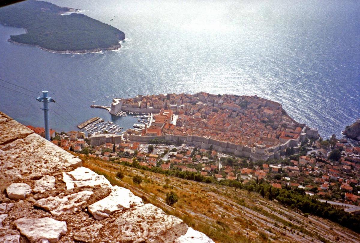 From a cliff overview, one can see the massive walls and large harbor of old Dubrovnik.