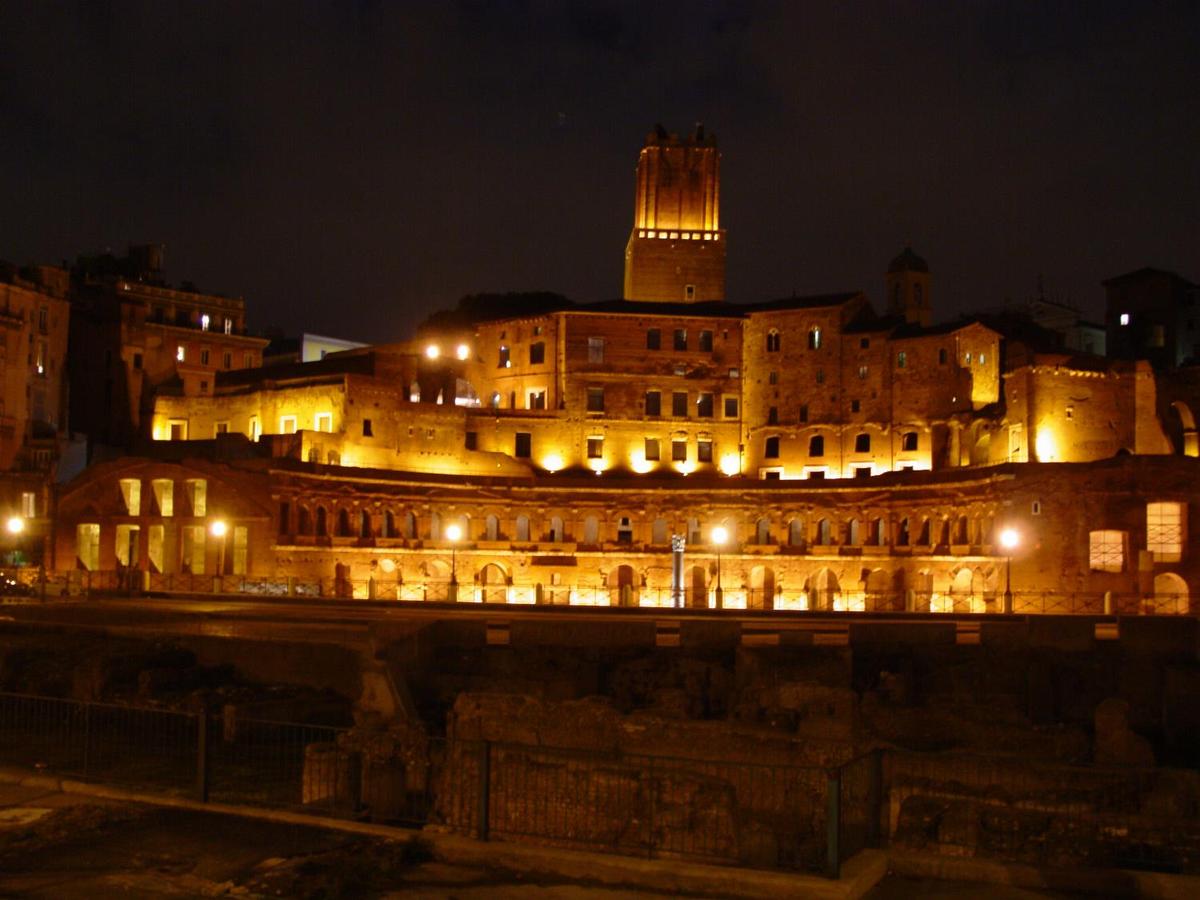 A nighttime view of Trajan's Market in Rome. Now a complex of ruins, it was built in A.D. 100-110. Its upper floor was filled by offices; a road divided it from the lower floor, which held shops.