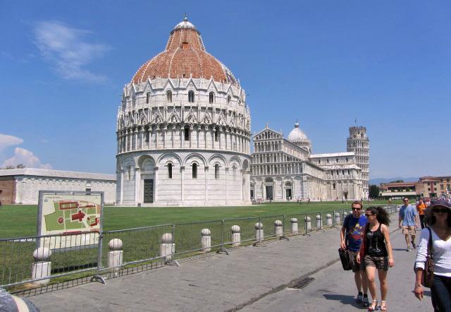 The Battistero di San Giovanni (Baptistry of St. John) in Pisa dates to 1153. The building on the left is the Camposanto or walled cemetery. To the right is the Duomo (Cathedral) and the Campanile (Leaning Tower).