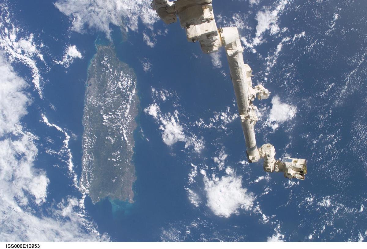 The Space Station Remote Manipulator System (SSRMS) or Canadarm2 appears against the Caribbean Sea in this view taken from the International Space Station. Puerto Rico is the large island on the left side of the frame. Click on photo to increase resolution. Image courtesy of NASA.