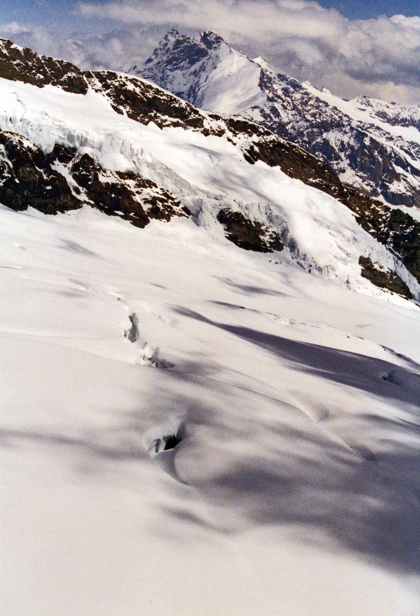 Snow, rocks, and peaks merge upward into the clouds.