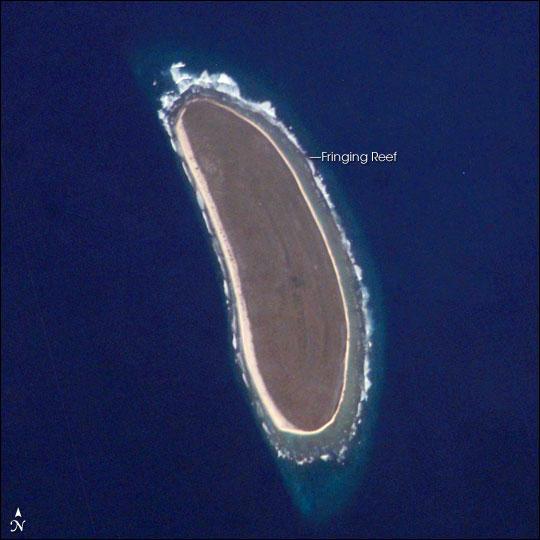 Howland Island is an uninhabited coral island located just north of the equator in the central Pacific Ocean, about 3,100 km southwest of Honolulu - almost halfway between Hawaii and Australia. The island is composed of coral fragments and is surrounded by an active fringing reef. White breakers encircling the island indicate the position of the reef. Image courtesy of NASA.