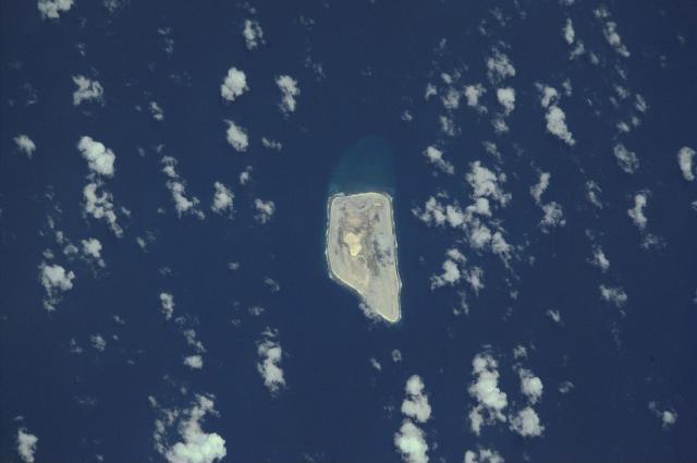 Jarvis Island is an uninhabited 4.5 sq km (1.75 sq mi) coral island located in the South Pacific Ocean. Unlike most coral atolls, the central lagoon on Jarvis is wholly dry. Note the submerged reef beyond the eastern shore of the island (top). Image courtesy of NASA.