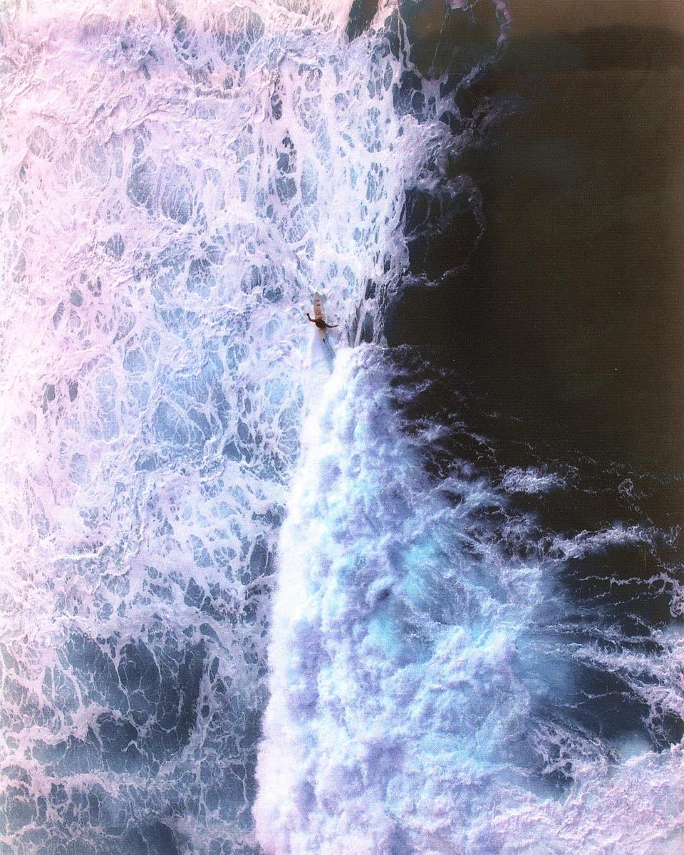 Solitary surfer along the North Shore of the Big Island of Hawaii.