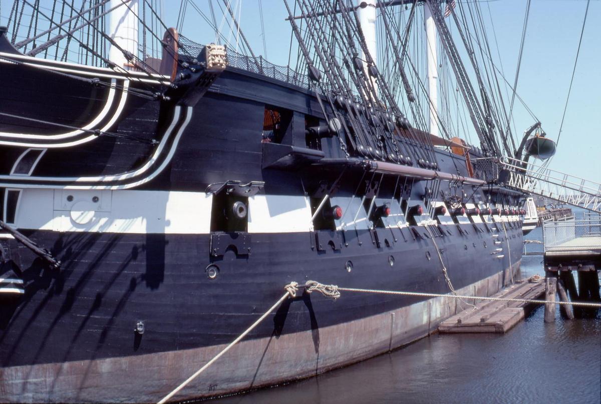 Gun ports of the USS Constitution. Although rated as a 44-gun frigate, the ship would often carry over 50 guns at a time. Constitution is 62 m (204 ft) long and 13.3 m (43.5 ft) at the beam. The height of the central mainmast is 67 m (220 ft).