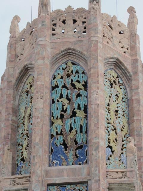 Closeup of the upper part of the Singing Tower at Bok Tower Gardens National Historic Landmark. The limestone structure includes tile mosaics, animal carvings, and custom iron-work.