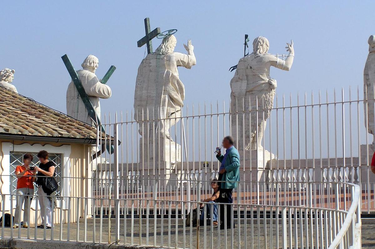 Behind the statues surmounting the facade of St. Peter's Basilica.