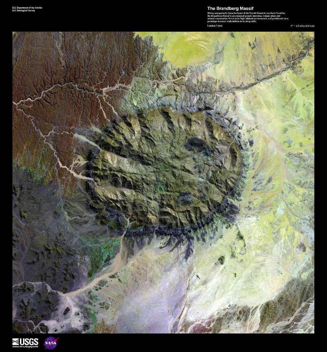 Rising unexpectedly from the heart of the Namib Desert, the Brandberg Massif, shown in this enhanced satellite image, is an exhumed granitic intrusion. As one of the highest mountains in Namibia at 2,573 m (8,439 ft), it formed when ancient magma chambers cooled and began to erode. Brandberg means fire mountain in Africaans, Dutch, and German. Unique plant and animal communities thrive in Brandberg's high-altitude environment, and prehistoric cave paintings decorate walls hidden in its steep cliffs, earning it status as a potential UNESCO World Heritage site. Image courtesy of USGS.