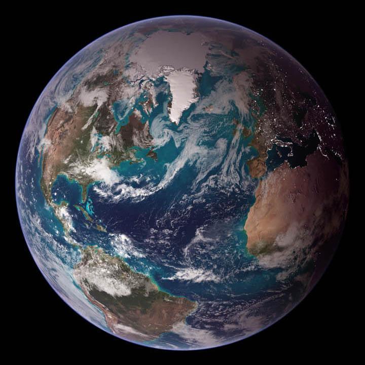 This "blue marble" image of the globe draws on data from multiple satellite missions (not all collected at the same time). The focus in this view is the North Atlantic Ocean and its surrounding land masses. Notice the thick ice pack on Greenland (top center) and the city lights on the night side of the globe. Image courtesy of NASA.