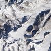 Besides the world's tallest peaks, the Himalayan Mountain Range holds thousands of glaciers. In southern China, just north of the border with Nepal, one unnamed Himalayan glacier flows from southwest to northeast, creeping down a valley terminating in a glacial lake. Shown in this natural-color satellite image, mountains on either side of the glacier cast long shadows to the northwest. From a bowl-shaped cirque, the glacier flows downhill. Where the ice passes over especially steep terrain, ripple marks on the glacier surface indicate the icefall. Northeast of the icefall, the glacier's surface is mostly smooth for several kilometers until a network of crevasses mark the surface. At the end of the glacier's deeply crevassed snout sits a glacial lake, coated with ice in this wintertime picture. Just as nearby mountains cast shadows, the crevassed glacier casts small shadows onto the lake's icy surface. This glacial lake is bound by the glacier snout on one end, and a moraine - a mound formed by the accumulation of sediments and rocks moved by the glacier - on the other. Image courtesy of NASA.