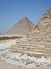 A view of a corner of the Khafre     pyramid reveals its stair-step construction. The Great Pyramid of Khufu appears in the distance.