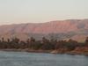 View along the Nile River at sunset south of Luxor. The land is green close to the river where is can be irrigated. Otherwise, it is desert.