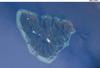 The tropical island of Moorea as viewed from the International Space Station. The barrier reefs surrounding the island create zones of shallow, tranquil light blue waters. Image courtesy of NASA.
