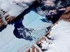 The Petermann Glacier grinds and slides toward the sea along the northwestern coast of Greenland, terminating in a giant floating ice tongue. Like other glaciers that end in the ocean, Petermann periodically calves icebergs. In July 2012, a massive ice island broke free and gradually drifted down the fjord, away from the floating ice tongue from which it calved. This satellite image has been rotated and north is toward the right. Analysis of the image reveals that the iceberg covers an area of about 32.3 sq km (12.5 sq mi). Image courtesy of NASA.