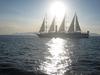 A sailing vessel plies the sun-drenched Aegean Sea.
