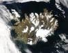 Summer temperatures melt snow and ice on much of Iceland's surface, as shown on this satellite image. The lack of uniform snow cover allows permanent (though shrinking) icefields to show through (particularly Vatnajokull in the southeast), and highlights the island's rugged coastline. Scores of fjords edge the island, resembling feathers waving out into the waters of the northern Atlantic Ocean (bottom) and Greenland Sea (upper left).
Though Iceland's climate is relatively mild and humid thanks to the North Atlantic Drift, and though the island's active volcanism provides inexpensive heating, only about the a quarter of the island is habitable, most of that along the coastlines. Photo courtesy of NASA.