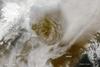 On 21 May 2011, Grimsvoetn volcano rumbled to life and sent off a plume of ash and steam about 20 km (12 mi) into the atmosphere. Above Grimsvoetn&apos;s summit, volcanic ash formed a circular brown plume that towered above the surrounding clouds. In the southeast, ash colored the snow surface dark brown. Ash from the volcano also reduced visibility to about 50 m (160 ft) in some areas, causing night-like darkness in the middle of the day. Image courtesy of NASA.