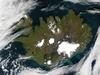 Summer is winding to a close on 9 September 2002, but even Iceland is still showing some summer color, its perimeter tinged with green, while its large permanent ice caps stand out brightly against the volcanic rock surrounding them. The largest ice cap, Vatnajokull, actually rests on top of three active volcanoes. The heat from these volcanoes causes the underside of the ice cap to melt, slowly filling the calderas. Eventually the caldera spills over and releases a torrent of water known as a glacial melt flood. This volcanic activity happens because a tectonic boundary runs roughly northeast-southwest through the island country, and the two plates are pulling away from each other, causing magma to well up from deep in the Earth. The brightly colored lakes and coastal waters are the result of very fine, and highly reflective sediment that is ground to bits by the immense weight of the glaciers and washed out with glacial runoff. Image courtesy of NASA.