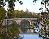 The Garibaldi Bridge over the Tiber River in Rome. The dome of St. Peter's Basilica appears in the background.