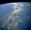This high-oblique, northeast-looking space shuttle photograph captures a portion of Southern Honshu Island and Shikoku Island of Japan. The darker areas show volcanic, mountainous terrain that comprises more than 80 percent of Japan; the lighter, more highly reflective areas of the coastal plains and valleys are urban and agricultural areas. Separated by the Seto Inland Sea are Shikoku Island to the south and the Osaka-Kobe industrial metroplex on Honshu Island to the north. Photo courtesy of NASA.