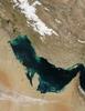 Much of the sediment clouding the water in this image of the Persian Gulf is from the Shatt al Arab River, which enters the Gulf in the north along the Iran-Iraq border. The river drains the combined waters of the Euphrates and Tigris Rivers of Iraq, and the Karun River of Iran. Though other rivers empty into the Persian Gulf, most of its fresh water comes from the Shatt al Arab. On the right edge of the image is the narrow Strait of Hormuz, which connects the Persian Gulf to the Arabian Sea, part of the northern Indian Ocean. The Persian Gulf is flanked to the west by wedge-shaped Kuwait and by Saudi Arabia with its vast tan-, pink-, and white-sand deserts; to the south by Qatar, the United Arab Emirates, and Oman; and to the east by the dry mountains of Iran. The wetlands and rivers of Mesopotamia border the Gulf on the north. The red dots mark gas flares in oil fields of Iran and Iraq. Image courtesy of NASA.