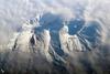 Russia&apos;s eastern Kamchatka Peninsula, which extends far into the Pacific Ocean, includes more than 150 volcanoes. While most are not actively erupting, many are considered dangerous due to their eruptive history and proximity to population centers and air travel corridors. This astronaut photo highlights the summit crater and snow-covered slopes of Avachinshy stratovolcano (2,741 m; 8,993 ft) as it pokes above a surrounding cloud deck. The volcano has an extensive historic and geological record of eruptions, the latest activity ocurring in 2008. To the southeast (image right), the large breached crater of Kozelsky volcano also appears above the clouds. Kozelsky is a parasitic cone, formed by the eruption of material from vents along the flank of Avachinsky. Photo courtesy of NASA.