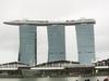 View of the Marina Bay Sands complex in Singapore that opened in 2010 and has since become a city landmark. The three 55-story towers contain hotel rooms. The upper level Sky Park, built to resemble a ship, has the world's longest elevated swimming pool, restaurants, gardens, and a public observation deck. The integrated resort also includes an adjacent ArtScience Museum, a casino, and a convention center.