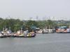 Fishing boats on the Chao Phraya River with the skyline of Bangkok in the background. 