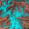 The Pamir Mountains include some of the world's tallest peaks, soaring to heights of 7,300 m (24,000 ft ). Centered in eastern Tajikistan, the Pamirs - part of the 'roof of the world' - are home to thousands of glaciers. Among them is Fedchenko, which at 77 km (47 mi) is the longest glacier outside of the Earth's polar regions. The melt waters of Fedchenko Glacier feed into the Muksu, Vakhsh, and Amu Darya Rivers before eventually making their way to the Aral Sea some 2,000 km (1,200 mi) away. In arid central Eurasia, the snow- and glacier-covered mountains serve as the region's water towers. Nearly 90% of the Central Eurasian population relies on water from the mountains for energy, agricultural, and drinking purposes.In this false-color image from 2 October 2011, the Fedchenko Glacier can be seen as it snakes its way northward from the western slopes of Independence Peak. The sparsely vegetated, arid mountains appear reddish-brown, while snow and ice are bright cyan. (Due to the angle of sunlight, this image may cause an optical illusion known as relief inversion.) Throughout the glacier's 77 km course, it drops 2,500 m (8,200 ft) in elevation. At the highest elevations, the glacier is snow and ice covered; but as it flows downstream, it picks up rockfall debris. Reddish-hued debris lines running parallel to the flow direction begin about midway down the glacier's length. These medial moraines widen as the glacier descends. At its terminus, the glacier is completely covered by debris. Image courtesy of NASA.