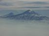 A view of Mount Ararat in eastern Turkey through the fog. The highest of its two peaks, Greater Ararat, is the tallest mountain in Turkey at 5,166 m (16,949 ft). Although located some 32 km (20 mi) from the Armenian border, the dormant volcano dominates the skyline of Yerevan, Armenia&apos;s capital. This photo was snapped after take off from the Yerevan airport.