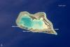 The atoll of Wake Island is composed of Wake Island proper and the smaller Peale and Wilkes Islands for a total land surface area of 6.5 sq km (2.5 sq mi). Like many atolls in the Pacific, the islands and associated reefs formed around a submerged volcano. The lagoon in the center of the islands marks the approximate location of the summit crater. Image courtesy of NASA.