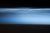 Polar mesospheric clouds - also known as noctilucent or "night shining" clouds - form between 76 to 85 km (47 to 53 mi) above the Earth's surface, near the boundary of the mesosphere and thermosphere, a region known as the mesopause. At these altitudes, water vapor can freeze into clouds of ice crystals. When the sun is below the horizon and the ground is in darkness, these high clouds may still be illuminated, lending them their ethereal, "night shining" qualities.
Polar mesospheric clouds have been observed from all human vantage points in both the Northern and Southern Hemispheres - from the surface, in aircraft, and from spacecraft - and tend to be most visible during the late spring and early summer. Image courtesy of NASA.